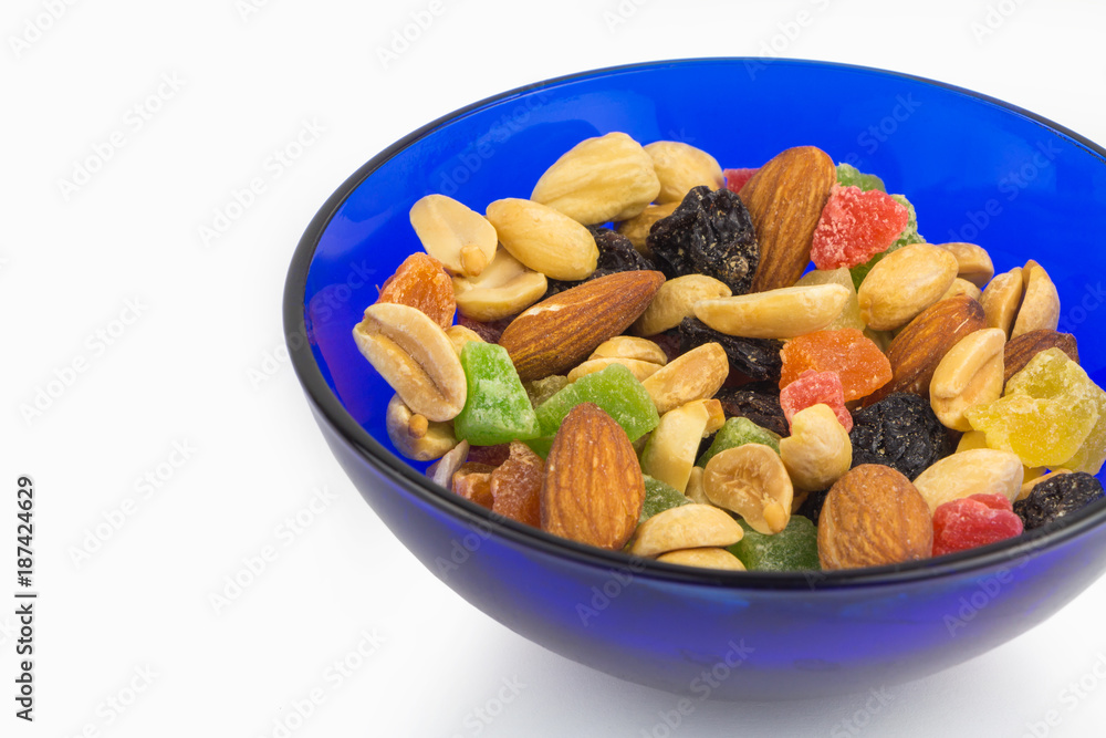 Fototapeta premium Dried fruits and nuts in blue bowl, proper nutrition, closeup
