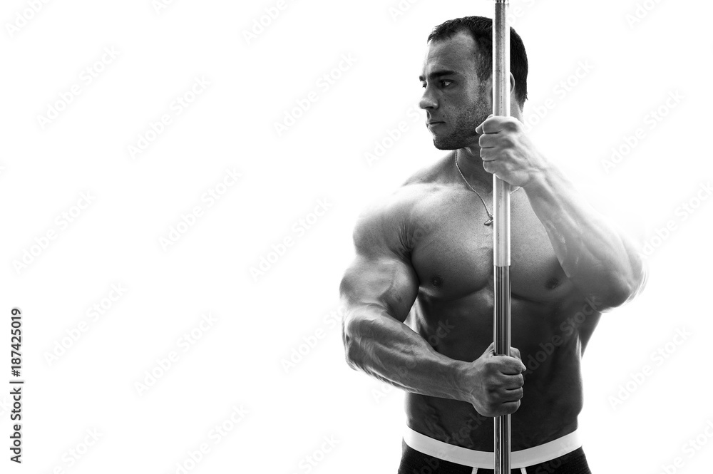 Handsome male fitness model posing shirtless, holding barbell in hands. Black and white image, place for text. High resolution. Handsome male fitness model posing shirtless, holding barbell in hands. Black and white image, place for text. High resolution.