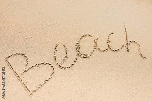 Beach word is written on the beach sand