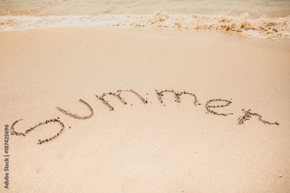 Fototapeta premium Summer word is written on the beach sand