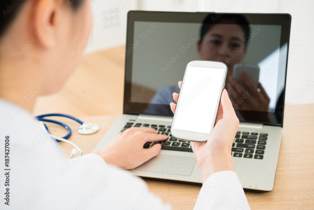 pretty young doctor looking at mobile cell phone pretty young doctor looking at mobile cell phone