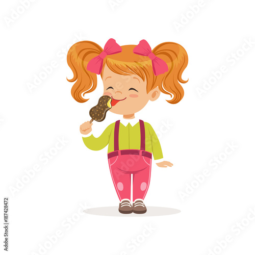 Cheerful little child licking delicious chocolate ice-cream. Red-haired girl with twintails in green blouse and pink pants with suspenders. Flat vector illustration