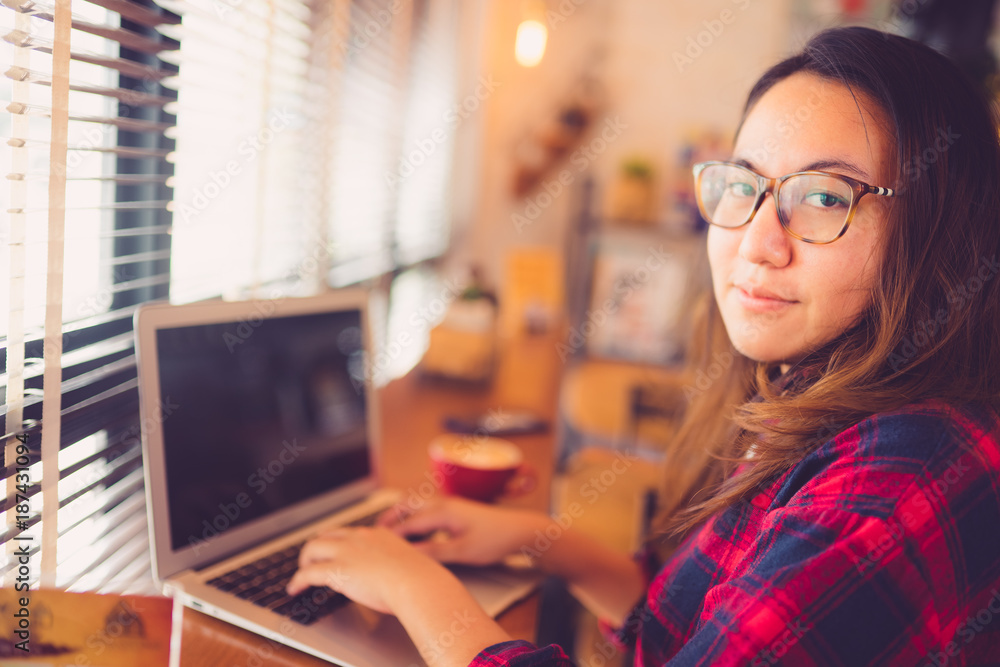 Happy hipster young woman working on laptop in the coffee cafe. Happy hipster young woman working on laptop in the coffee cafe.