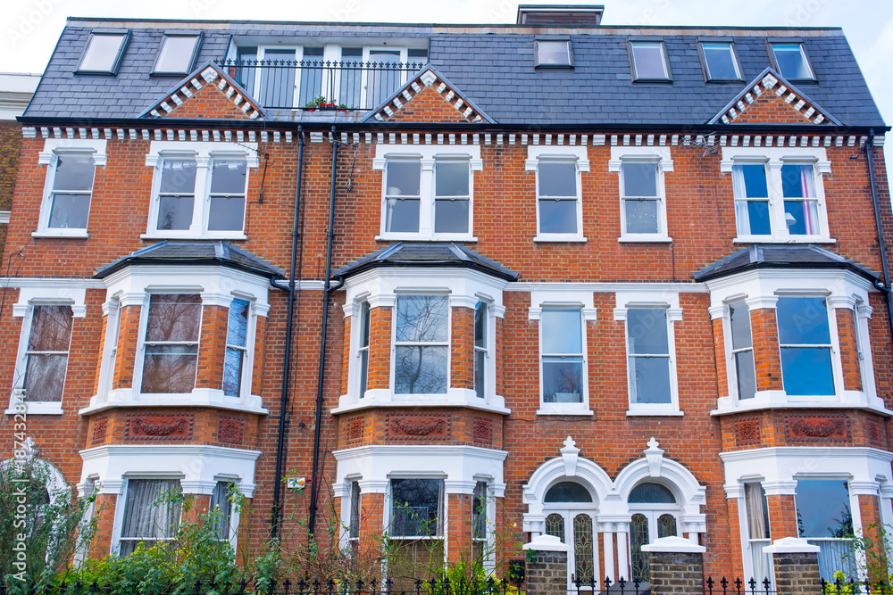 Facade of an opulent restored Victorian house in red bricks and white finishing in Clapham, South London, UK