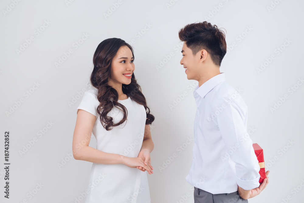 Love. Handsome young Vietnamese man giving present to beautiful woman at home Love. Handsome young Vietnamese man giving present to beautiful woman at home