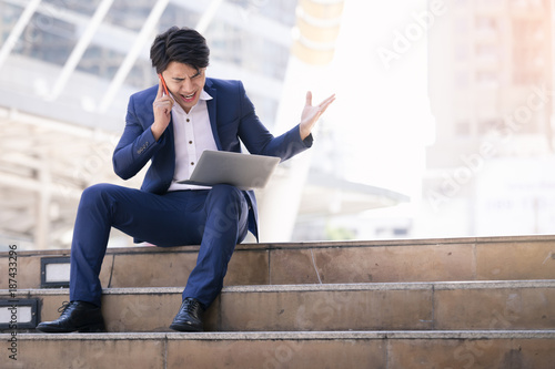 Asian business man failing and serious work on phone and laptop in the city Free Download Asian business man failing and serious work on phone and laptop in the city - GFXLoad