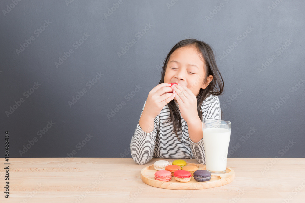 Cute little girl eating sweet macarons Cute little girl eating sweet macarons