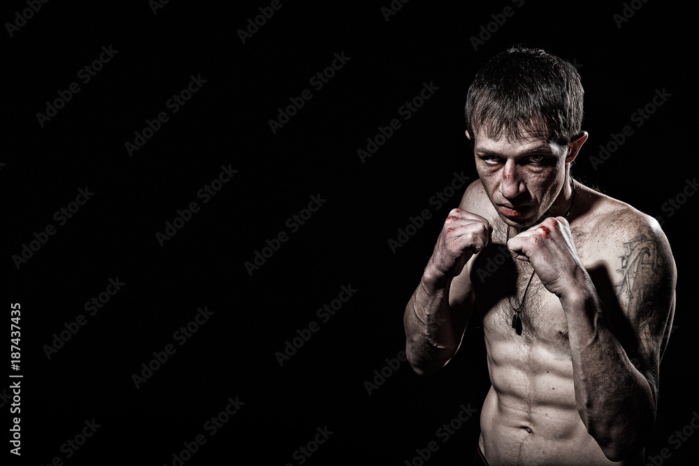 Fighting man with bloody  knuckles on black background