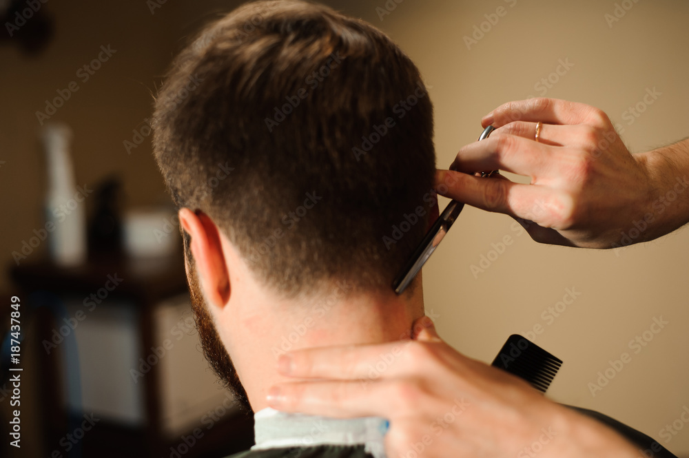 Master cuts hair and beard of men in the barbershop Master cuts hair and beard of men in the barbershop