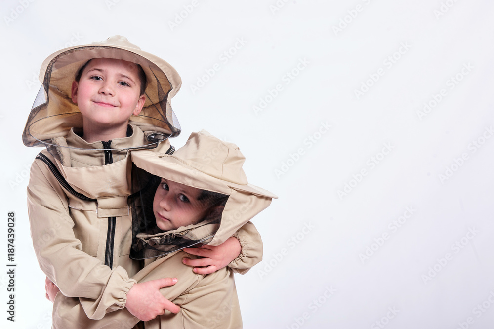Kids in beekeeper's suits posing in studio white background. Kids in beekeeper's suits posing in studio white background.