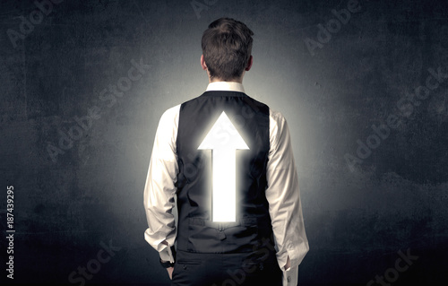 Young businessman standing with arrow on his back