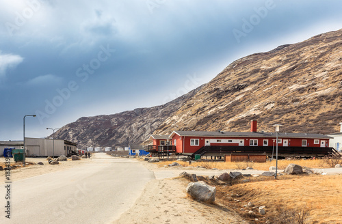 Street in Kangerlussuaq settlement with small living houses among mountains, Greenland photo