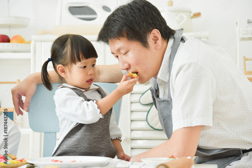 Asian Kids feeding cookie to her father. Asian Kids feeding cookie to her father.