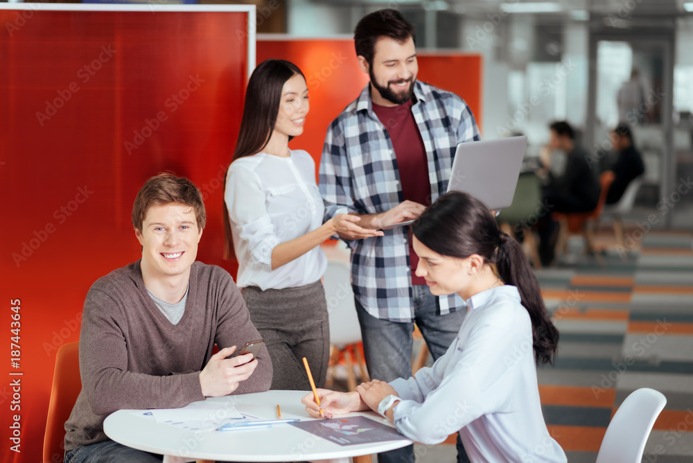 Flirt at work. Glad jolly two colleagues sitting at the table while working with documents and woman flirting with guy Flirt at work. Glad jolly two colleagues sitting at the table while working with documents and woman flirting with guy