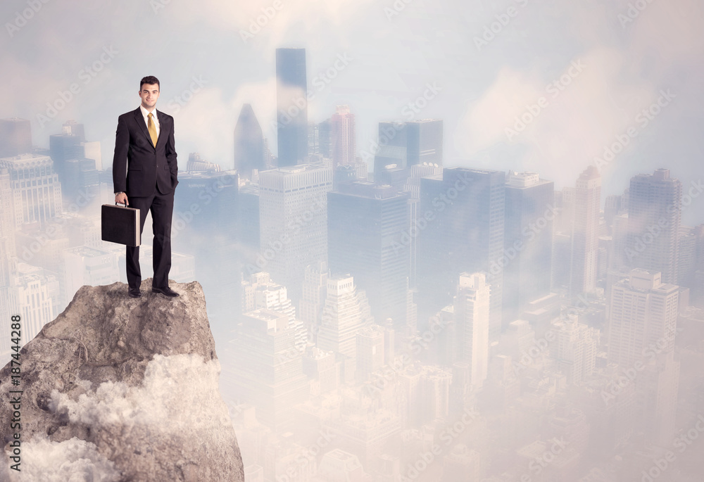 Winner urban businessman on top of stone Winner urban businessman on top of stone