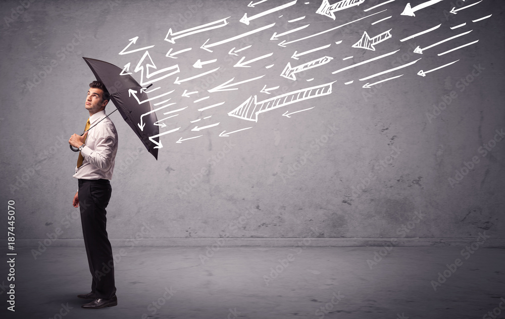 Business man standing with umbrella and drawn arrows hitting him Business man standing with umbrella and drawn arrows hitting him
