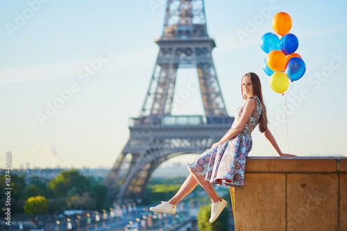 Young woman with bunch of balloons near the Eiffel tower