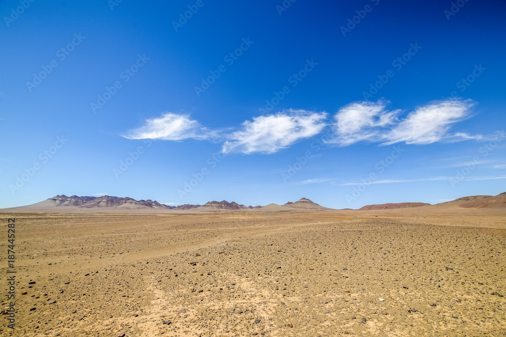 Beautiful wide angle view of the Namibian Desert and mountains in the background at the road between Vioolsdrift and Aussenkehr near the South African border. Blue sky and beautiful clouds.