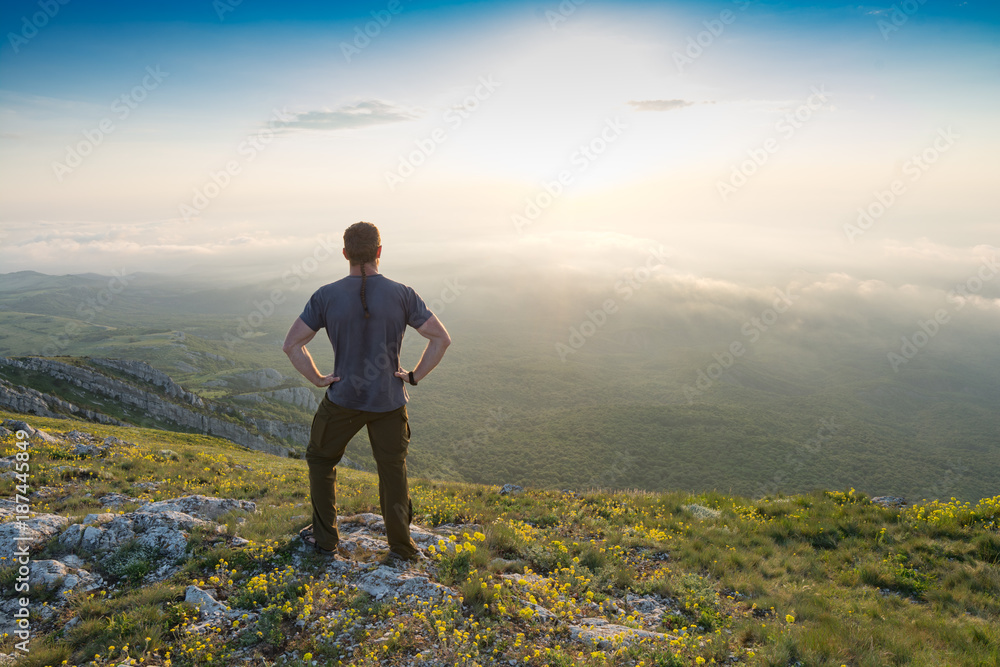 Young hiker man standing on a rocky hill