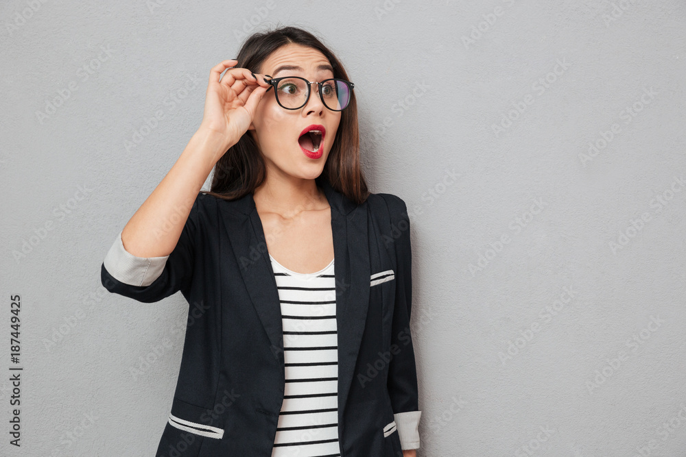Shocked business woman in eyeglasses looking away with open mouth Shocked business woman in eyeglasses looking away with open mouth