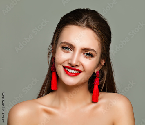 Young Cheerful Woman with Red Lips Makeup and Jewelry Earrings. Perfect Model Smiling