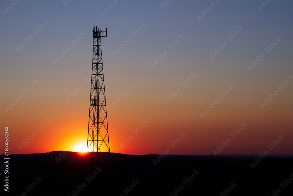 Sunset behind the communication tower. Mobile phone transmitter in the evening. 