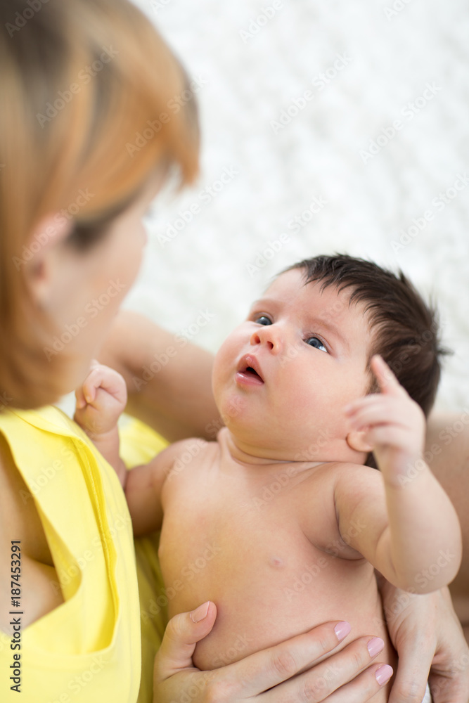 Funny newborn baby and mother looking each at other Funny newborn baby and mother looking each at other