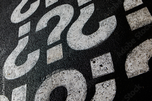 Fragezeichen auf Asphalt