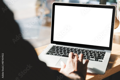 Man using laptop with blank screen at table in the office