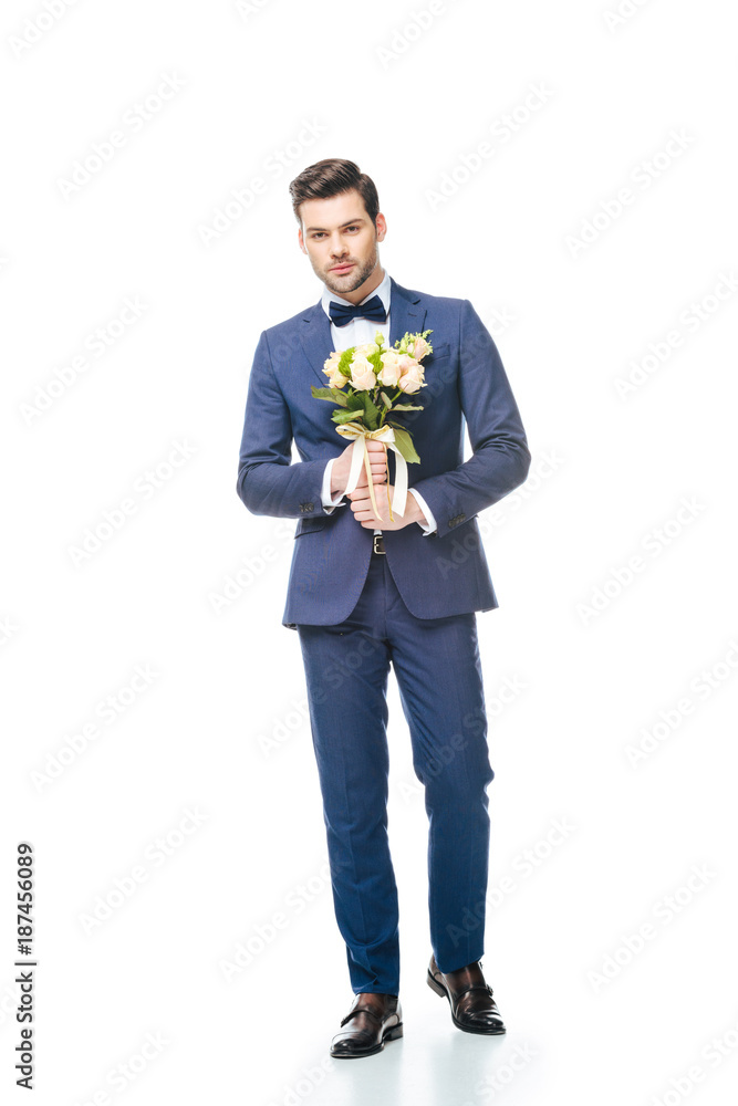 fashionable groom with wedding bouquet in hands isolated on white fashionable groom with wedding bouquet in hands isolated on white