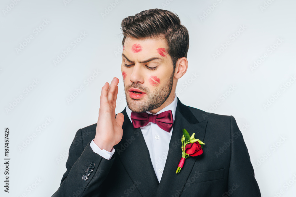 portrait of handsome groom in suit with red lipstick on face portrait of handsome groom in suit with red lipstick on face