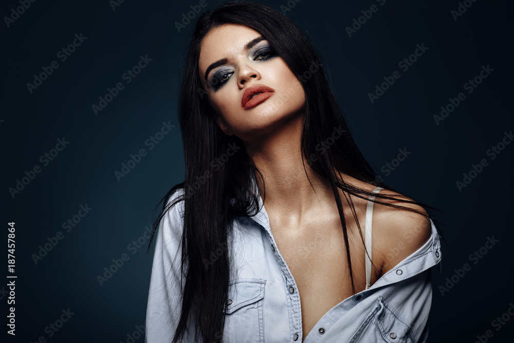 Naklejka premium Beauty portrait of a young black-haired woman in the studio