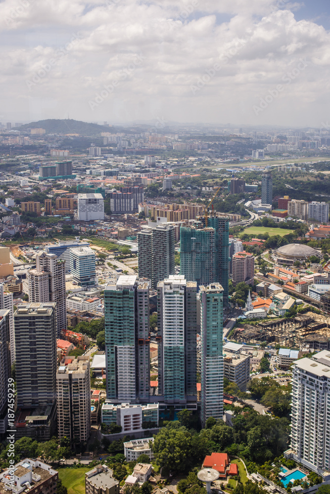 Urban views of Kuala Lumpur with tall skyscrapers, drowning in the greenery of parks