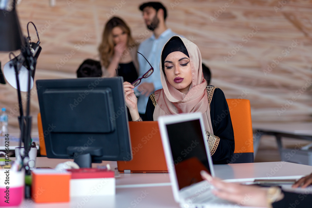 Attractive Muslim young woman working in office on computer Attractive Muslim young woman working in office on computer