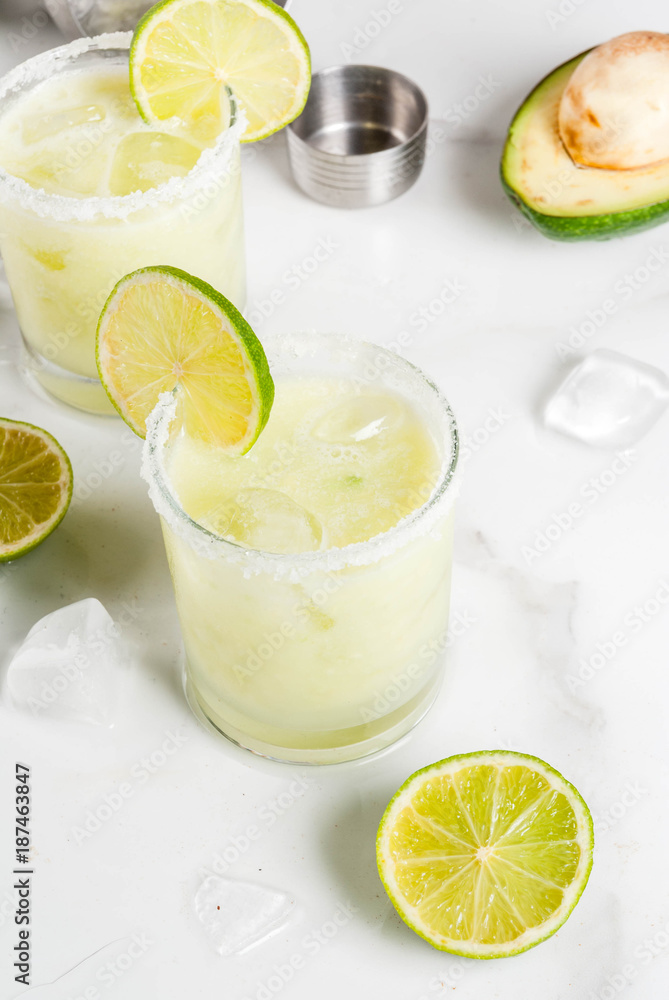 Alcoholic cocktail recipes and ideas. Avocado and lime margarita with salt, on a white marble kitchen table. Copy space Alcoholic cocktail recipes and ideas. Avocado and lime margarita with salt, on a white marble kitchen table. Copy space