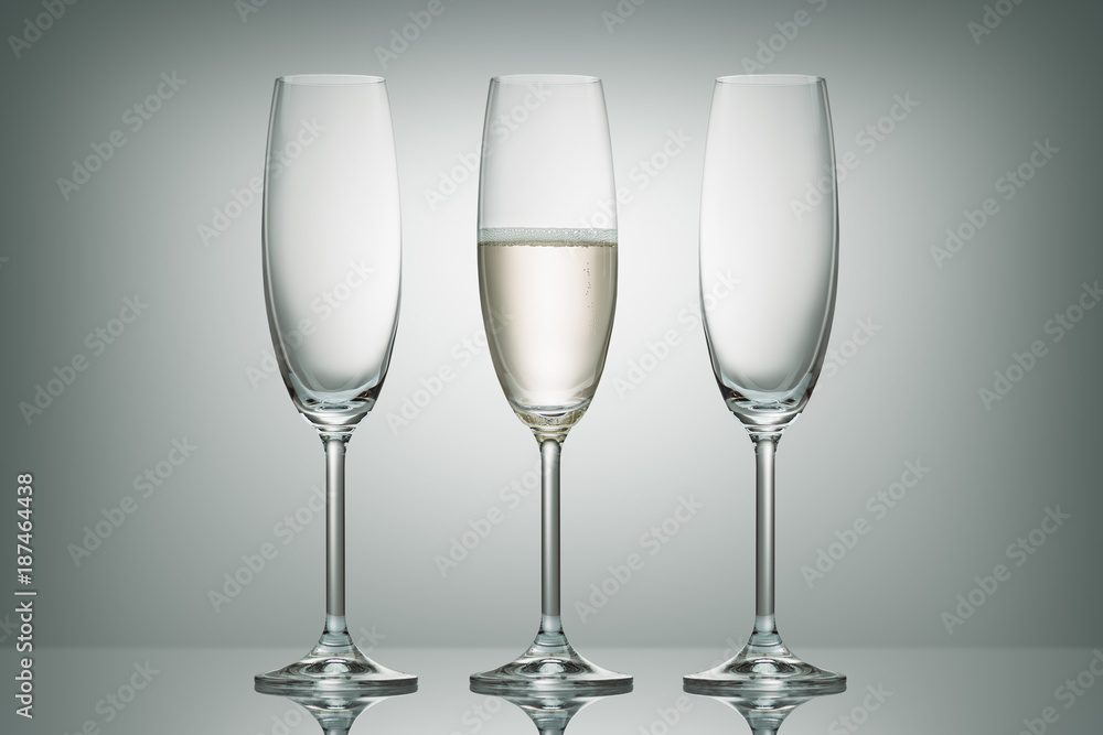 two empty glasses and one glass with champagne on white two empty glasses and one glass with champagne on white