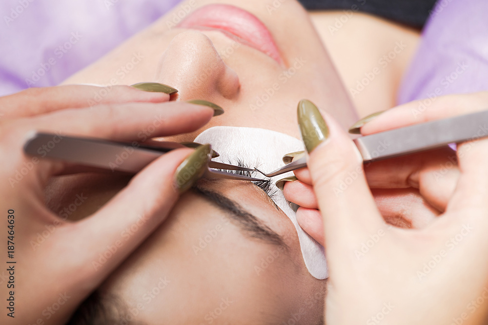 Fotografie Cosmetician making artificial eyelashes on client's eye