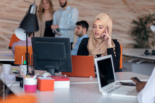 Bild auf Leinwand Attractive Muslim young woman working in office on computer