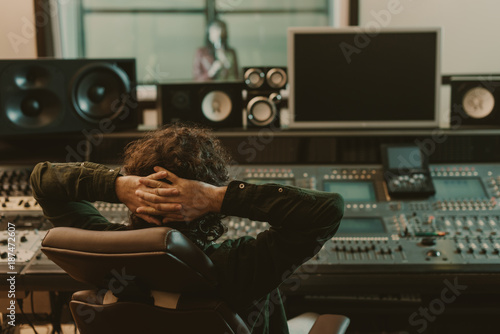 sound producer relaxing in armchair at recording studio