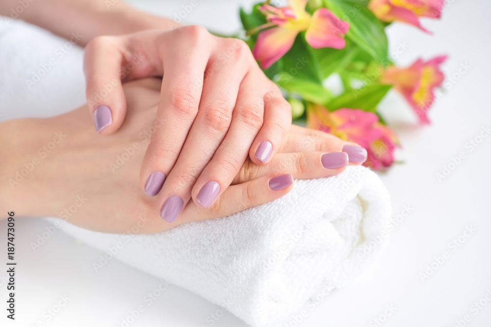 Hands of a woman with pink manicure are on a towel Hands of a woman with pink manicure are on a towel