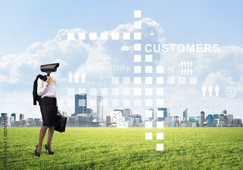 Camera headed woman standing on green grass against modern cityscape Camera headed woman standing on green grass against modern cityscape