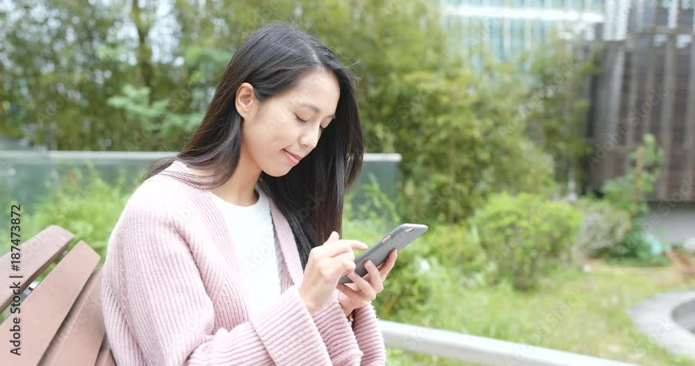 Woman use of cellphone and sitting on the bench