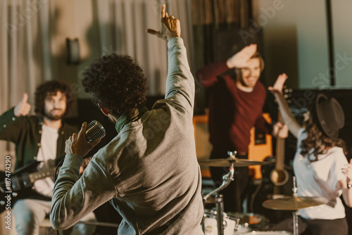 singer stretching hand to happy music band while they having repetition