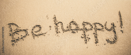 Be Happy text written on the sand