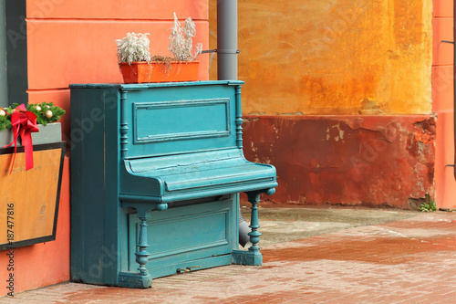 Vintage weathered aquamarine piano outdoor in the street downtown