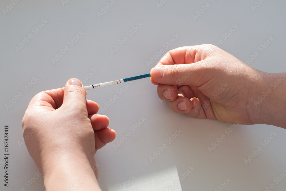 A woman holds a positive pregnancy test with two stripes A woman holds a positive pregnancy test with two stripes