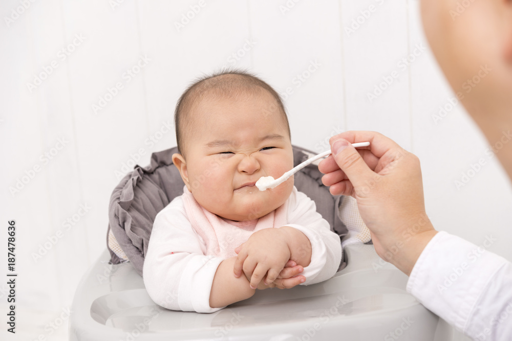 赤ちゃんに離乳食を食べさせる父親 赤ちゃんに離乳食を食べさせる父親