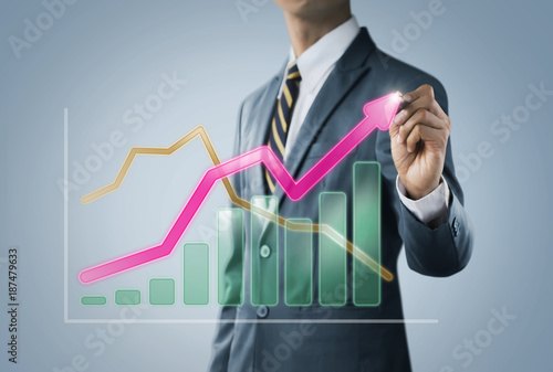 Business growth, progress or success concept. Businessman is drawing a growing 3d virtual hologram graph on bright tone background.