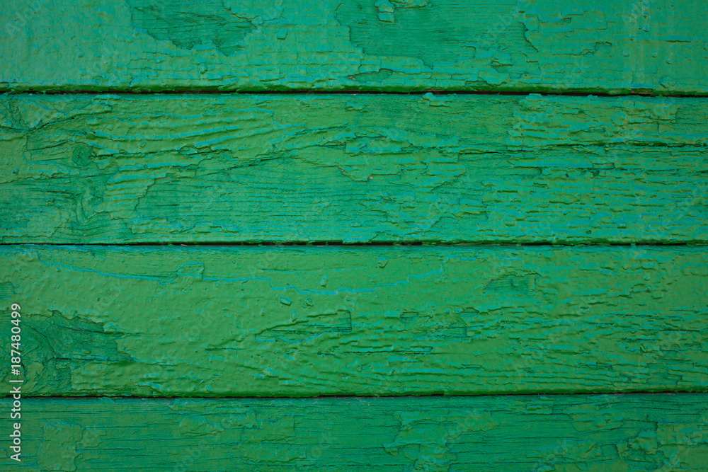 Wooden boards painted in green. Old green background. Painted wood surface. The surface of the wooden green train car. The parallel lines of the boards Wooden boards painted in green. Old green background. Painted wood surface. The surface of the wooden green train car. The parallel lines of the boards