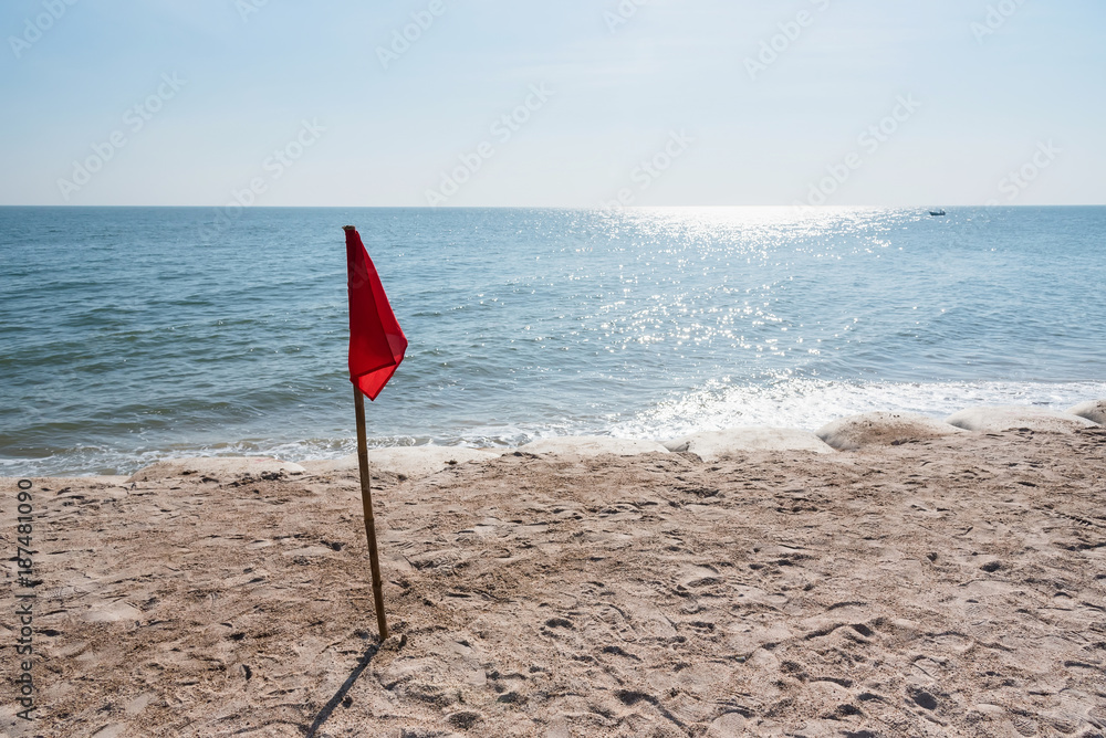 Warning sign of a red flag at a beautiful beach with a blue sky at Cha Am beach of Thailand. Warning sign of a red flag at a beautiful beach with a blue sky at Cha Am beach of Thailand.